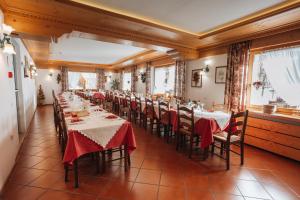 瓦尔迪佐多Hotel Edelweiss的餐厅的一排桌子,有红色桌布