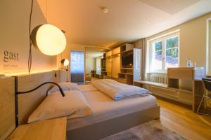 巴登林德费四利斯巴赫兰德酒店的一间卧室配有一张带灯和窗户的床