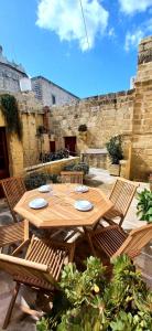 阿尔卜Il Mithna farmhouse with indoor heated jacuzzi pool的一张木桌、两把椅子和一张桌子