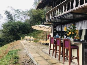 和平Mường Ecolodge Hòa Bình的大楼外的桌椅和遮阳伞