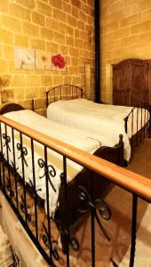 阿尔卜Il Mithna farmhouse with indoor heated jacuzzi pool的卧室设有两张单人床,拥有砖墙
