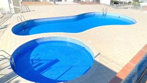 罗萨斯Acapulco b5的大型蓝色游泳池,位于瓷砖地板