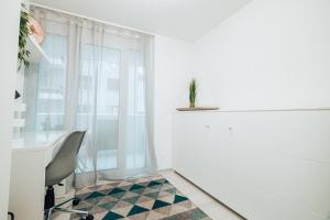 菲斯普Central Apartment - culture & nightlife in one的白色的客房设有椅子、书桌和窗户