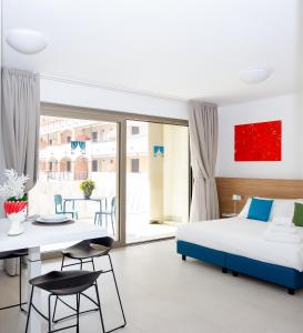 格拉多Ariston Teatro Luxury Aparthotel的卧室配有一张床和一张桌子及椅子