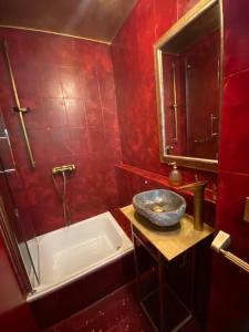 施塔弗尔湖畔塞豪森Extravagantes ganzes Haus am Staffelsee (DHH), Villa Kunterbunt的红色的浴室设有浴缸和水槽