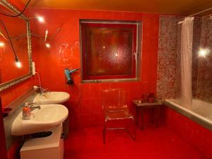 施塔弗尔湖畔塞豪森Extravagantes ganzes Haus am Staffelsee (DHH), Villa Kunterbunt的红色的浴室设有两个盥洗盆和一个浴缸。