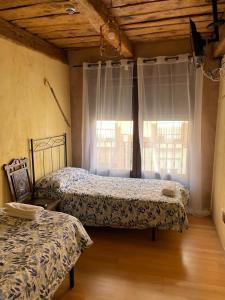 萨阿贡Albergue hostal Sahagún的一间卧室设有两张床和窗户。