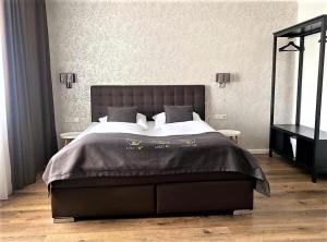 巴特恩豪森City Hotel ApartM3 am Park的一间卧室配有一张大床和黑色床头板
