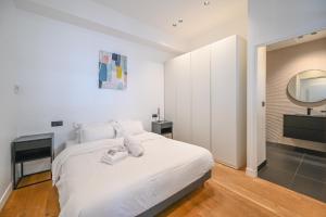 巴黎Appartement de Prestige - Grand Varenne的白色的卧室配有白色的床和镜子