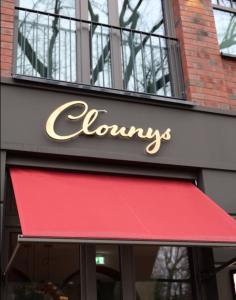 汉堡Clounys Hotel的建筑物上带有红色遮篷的商店标志