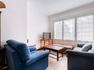 卡纳克Appartement Carnac, 3 pièces, 4 personnes - FR-1-477-100的客厅配有2把蓝色椅子和桌子