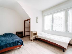 卡纳克Appartement Carnac, 3 pièces, 4 personnes - FR-1-477-100的一间白色卧室,配有两张床和镜子