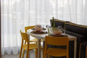 雅典Designer loft in heart of Athens nightlife的餐桌、两把椅子、一张白色桌子和两杯