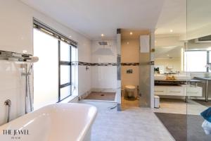 开普敦The Jewel B&B的白色的浴室设有浴缸和水槽。
