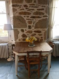 JunhacChambre indépendante - style studio - avec jardin à la campagne的一张木桌,上面有花瓶