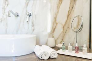 卡瓦拉EPICURE SUITES的浴室配有盥洗盆、镜子和毛巾