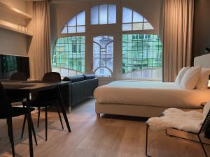 根特3 Bedroom Art-Nouveau Apartment with Free Parking的一间卧室配有一张床、一张桌子和一张沙发