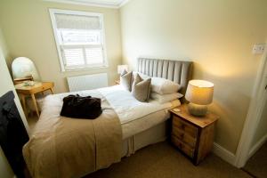 莱瑟姆-圣安妮Mulberry Cottage - Cosy 3 Bed Cottage near Lytham Windmill的一间卧室,配有一张带袋子的床
