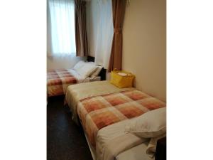 东京Tokyo stay Hut SARI - Vacation STAY 27239v的酒店客房带两张床,还有黄色的袋子