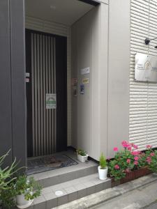 东京Tokyo stay Hut SARI - Vacation STAY 27239v的一座种植盆栽植物的建筑的前门