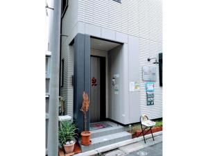 东京Tokyo stay Hut SARI - Vacation STAY 27239v的植物和椅子的建筑的门