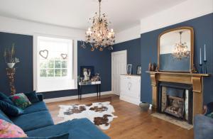 卡桑德Rame Barton Guest House and Pottery的蓝色的客厅设有壁炉和镜子