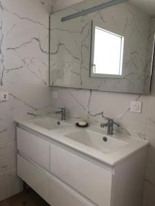 Lampaul-PlouarzelChez Yolande的白色的浴室设有水槽和镜子
