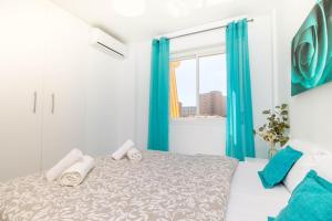 多列毛利诺斯Erisa 55 by IVI Real Estate的一间卧室配有一张带蓝色窗帘的床和一扇窗户