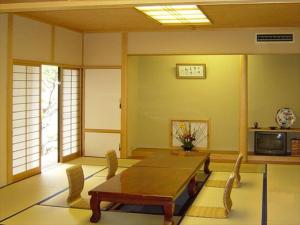 佐野市Rokugatsu-no-Mori Auberge的客厅配有木桌和椅子