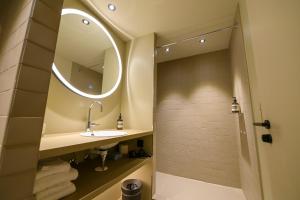 巴登林德费四利斯巴赫兰德酒店的一间带水槽和镜子的浴室
