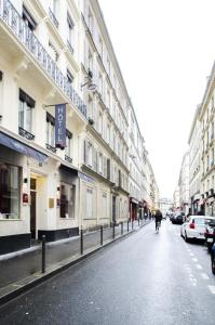 巴黎蒙马特歌剧院米尼酒店的骑着自行车沿着街道上建筑的人