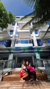 萨马尔Aundanao Oasis Beach的两个女人站在一座建筑物前