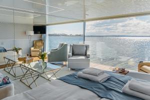 梅尔诺Domki na wodzie - HT Houseboats - with sauna, jacuzzi massage chair的游艇上的卧室,享有水景