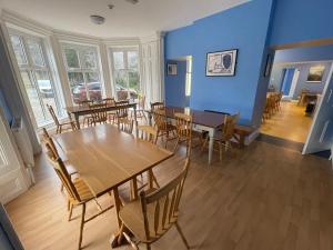 拉腊格兰达洛国际青年旅舍的一间拥有蓝色墙壁和木桌及椅子的用餐室