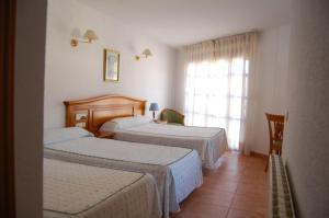 特拉加塞特埃尔加莫酒店的酒店客房设有两张床和窗户。