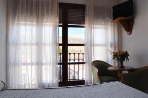 特拉加塞特埃尔加莫酒店的客房设有阳台景窗户。