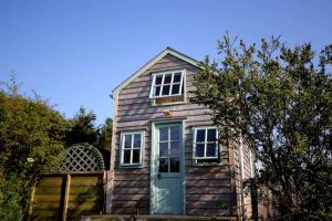 布德Tiny House on isolated farm by the Cornish Coast的一间设有蓝色门和窗户的木屋