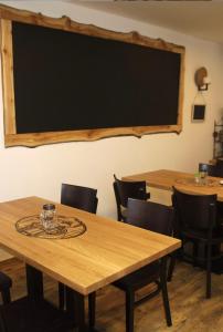 Penzion Puk的一间配有木桌和椅子的教室和黑板