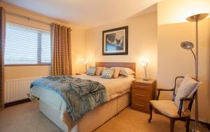 克拉姆林吉福汉娜乡村别墅酒店的卧室配有床、椅子和窗户。