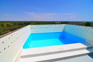 托雷科里梅纳Boomerang Residence a Torre Colimena的从带游泳池的房屋阳台欣赏风景