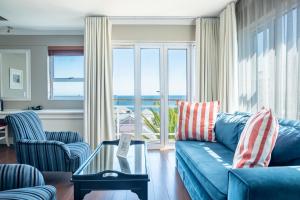 开普敦The Bantry Bay Aparthotel by Totalstay的客厅配有蓝色沙发,享有海景