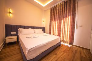 都拉斯Hotel Vila Misiri的一间卧室配有一张带白色床单的床和一扇窗户。