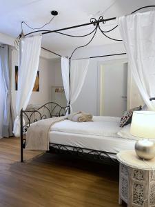 特伦托Ai Tre Garofani B&B的卧室配有带白色窗帘的天蓬床