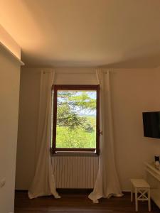 佩萨罗Villa Rina的客房设有带白色窗帘的窗户。