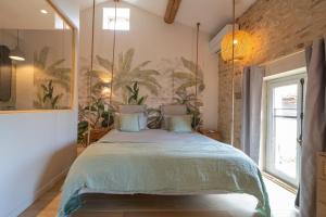 巴尼奥勒Songes de vigne的卧室配有一张大床,墙上挂有绘画作品