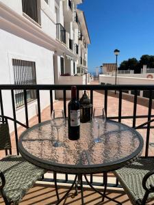 贝纳尔马德纳Casa Balcones - Benalmadena Pueblo的阳台上的桌子上放着两瓶和两杯眼镜