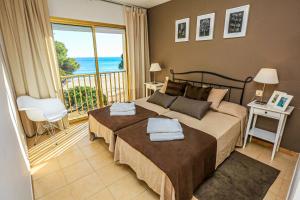 坎布里尔斯Playmar Litoral Costa Dorada - ONLY FAMILIES的一间卧室设有一张床和一个海景阳台