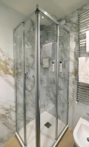 西尔米奥奈芳提波伊欧拉酒店的一个带水槽的玻璃淋浴间