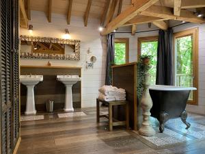 ClottesChâteaux dans les Arbres的浴室配有两个盥洗盆和浴缸。