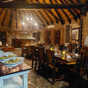 库斯Torgos Lodge的一间带木桌椅的餐厅和一间用餐室